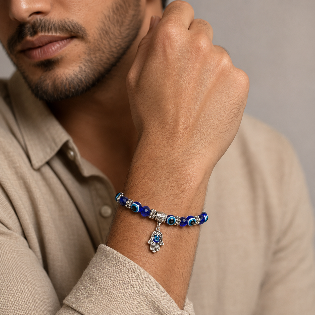 Rudvya Evil Eye Hamsa Bracelet worn by male model with beige shirt lifestyle styling
